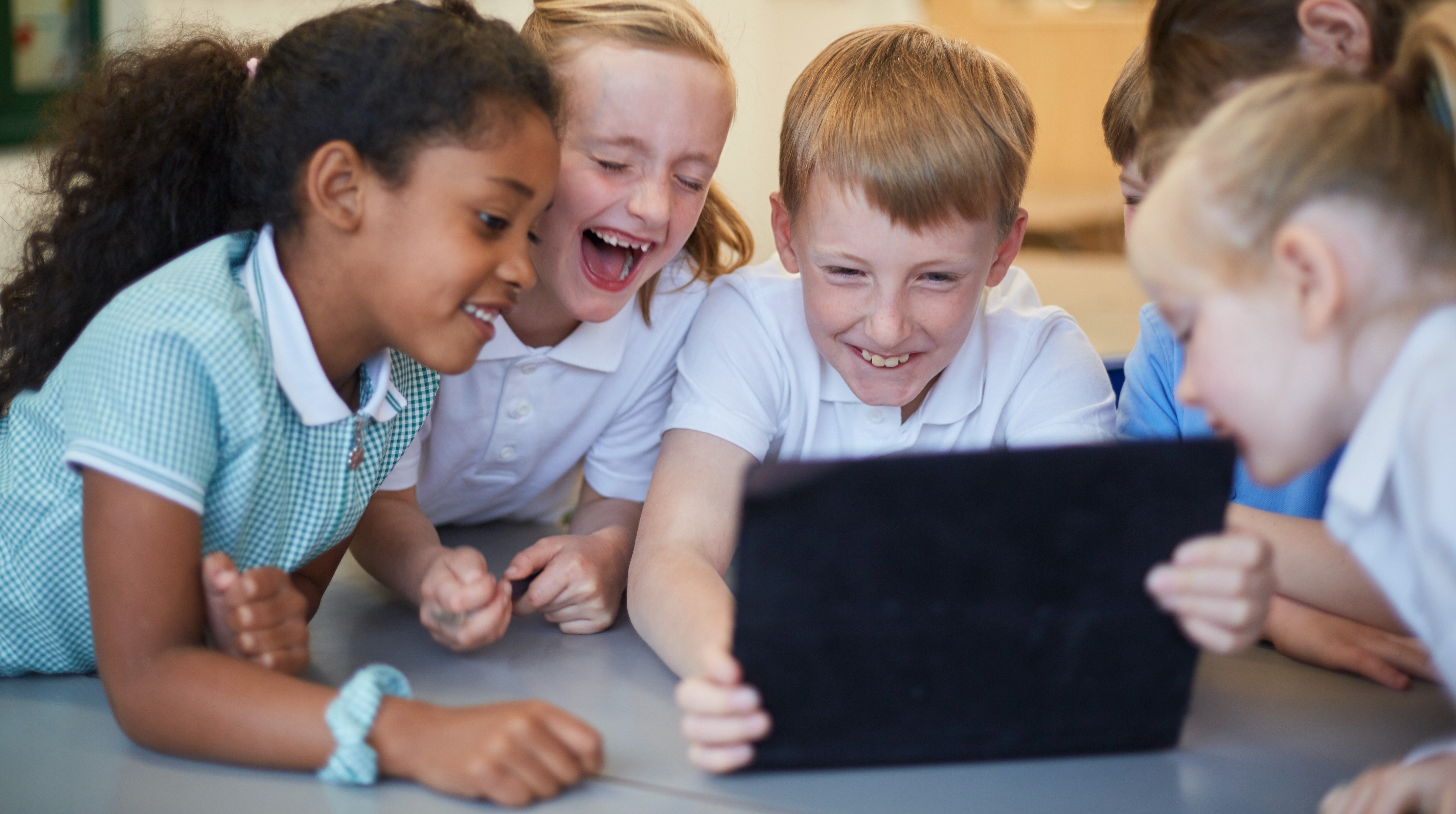 schoolboys-and-girls-laughing-at-digital-tablet-in-2022-03-04-01-52-01-utc